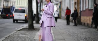 A girl in a purple suit stands on the street