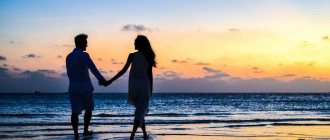 Мужчина и женщина идут по берегу, держась за руки